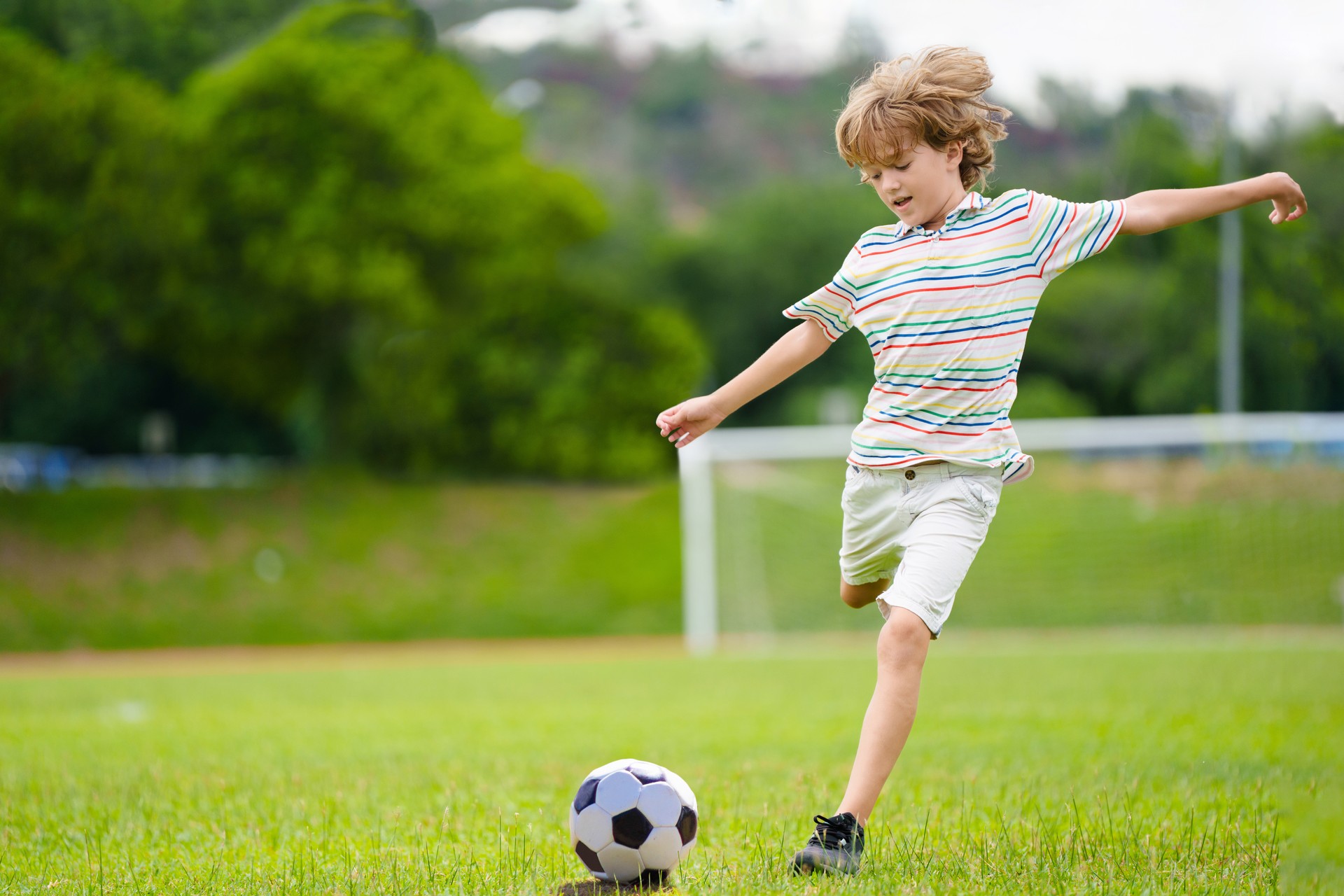 Child playing football. Kids play soccer.