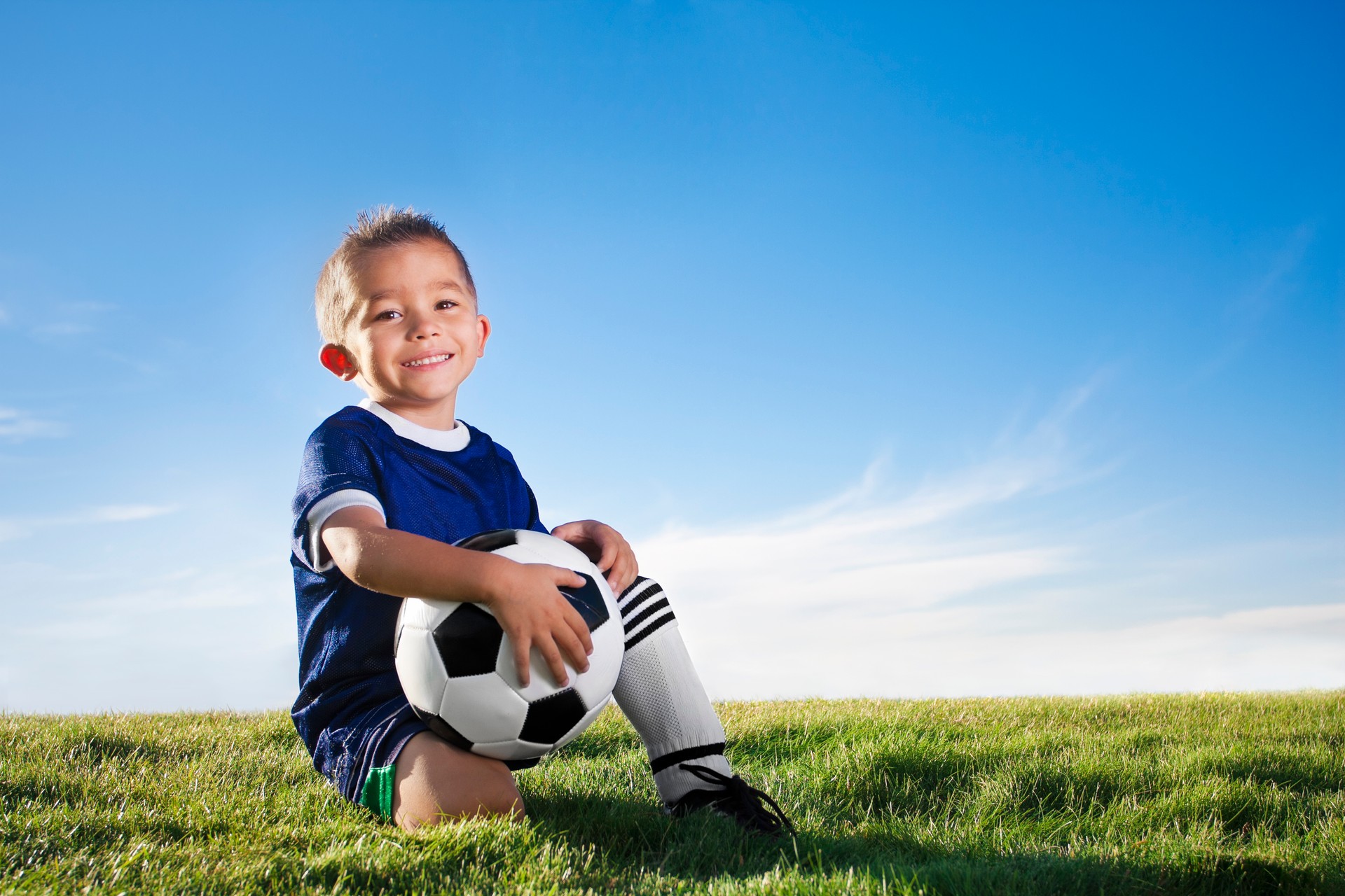 Portrait of a young boy wearing a soccer uniform in a field